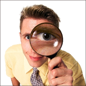 A man looking through a magnifying glass, as if looking for details.