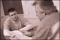 A counselor talks with a man about paperwork.