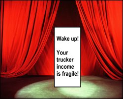 Curtains opening to sign on stage reading Wake up! Your trucker income is fragile!