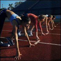 Female runners at the starting line of a race, competing for a prize.