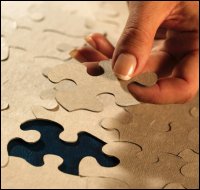 Fitting a puzzle piece in puzzle by hand.
