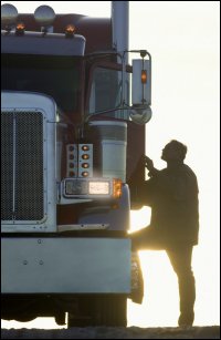 Trucker with foot on lowest step of truck.