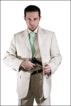 Man in suit with a gun in his hand.