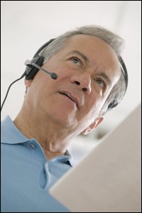 An older man wearing a headset, as if a dispatcher.