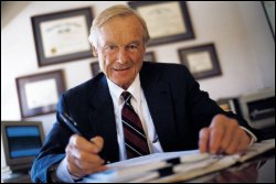 Man in suit and tie with paperwork.