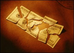 A hundred dollar bill torn in pieces - metaphor of lost savings.