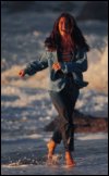 Woman wading in ocean water.