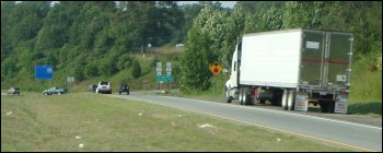 A truck parked on the shoulder of a ramp.