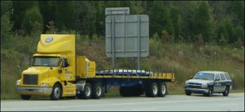 Tractor trailer pulled over on the shoulder by law enforcement.