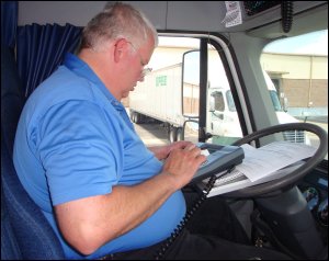 Mike uses the aluminum forms holder as a base for doing his paperwork and upon which to rest the QualComm mobile communications terminal when he has to send a message to his company.