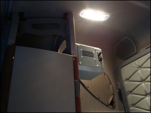 The inside unit of the Arctic Breeze Truck AC is mounted on the side of the cabinet toward the bunk behind the passenger seat.