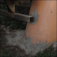 A close-up of the concrete post shows that this trailer is not the only one that has hit it. Many other drivers have parked too far back in the space and rammed it.