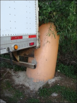 Trailer bumper hits concrete post upon parking too far back in the parking space.