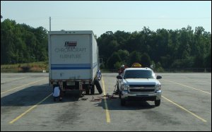 A service truck makes a repair to a big truck.