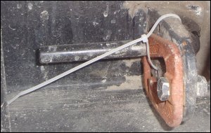 One cable tie securing a tie down on the corner of a container mounted on a chassis.