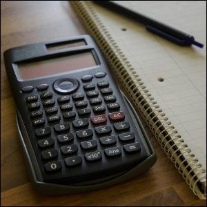 Calculator and pad with pen for writing down spending and saving.