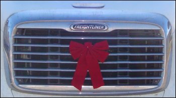 Red bow on truck grill as a Christmas decoration.