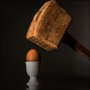 Mallet hovering over egg, symbolizing being coerced or forced to do something wrong, like falsifying a log book entry.