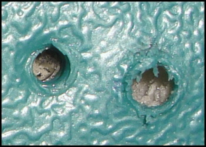 This is a close-up of two of the holes, in the body of the cooler. The one on the left is an original hole, the one of the right for the replacement hinge.