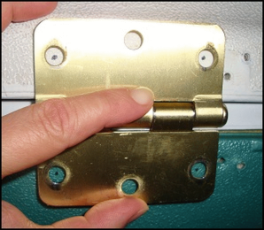 Vicki held the replacement hinge where she wanted it to go and marked the places for the screws.