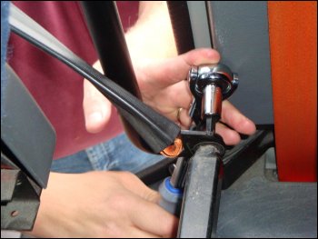 Removing the factory installed screw from the right side of the passenger seat, working carefully between the screw and the truck's wall.