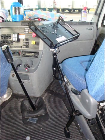 The Trucker's Workstation™ Laptop Stand by Cyber Trucker appears to be installed, but it is not completely upright; it is leaning toward the passenger seat back slightly.