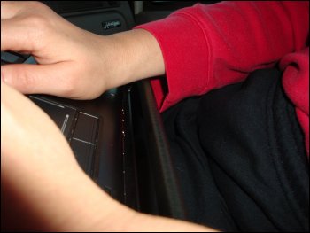 This photo shows her right wrist 'resting' on the front edge of the workstation. Although the metal edge is covered, it is certainly too high for Vicki to work in comfort.