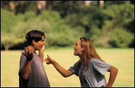 Girl pointing a finger at a boy, obviously accusing him of something. He has his hands up as if asking what he was supposed to do.