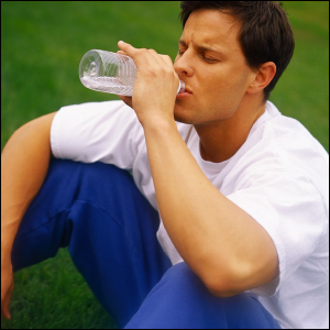 Man drinking water from a plastic bottle.