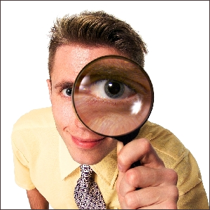 Man looking through magnifying glass.