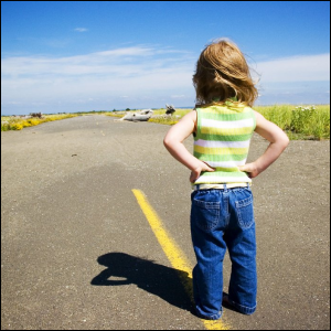 Little girl looking down the road.