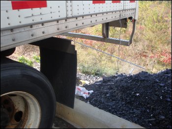 Backing the trailer axles up to a concrete curb to move them.