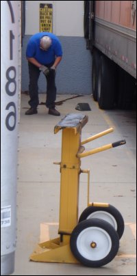 Mike Simons looks at the placement of a chock in front of the tires of a trailer backed in front of a dock.