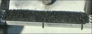 A door mat attached to the step of a truck with cable ties run around the step.