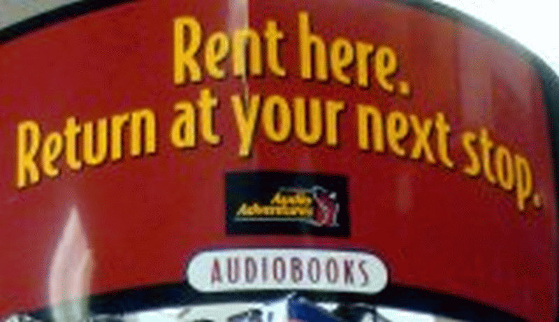 A close-up of a sign on an audiobooks display at a truck stop