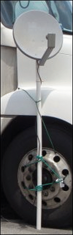 A close-up of a satellite dish mounted on the side of a truck.