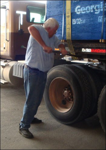 Mike cinches down a load strap using a breaker bar on the winch.