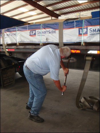 Mike cinches down a load strap using a breaker bar on the winch.