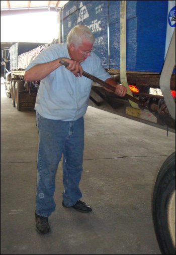 Mike cinches down a load strap using a breaker bar on the winch.