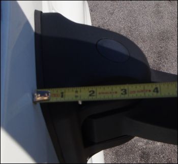 Measuring the hinge on which the folding mirror swings. Since the mirror fully folds in past the edge of the hinge mechanism, it can be less than four inches from the truck's side.