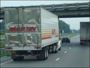 A big truck following behind a car at highway speeds on I-20, a little too closely.