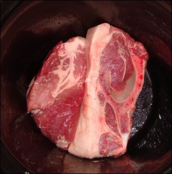 The first two pork ribs in the bottom of the crock pot.