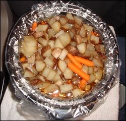 The completely cooked beef stew in a crock pot.