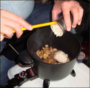 Adding cream of mushroom soup to mushrooms for beef stroganoff.