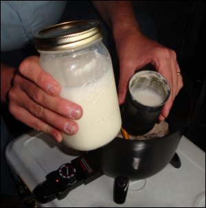 Milk being added to mushroom soup and mushrooms for beef stroganoff.