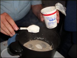 Adding sour cream to the mushroom soup mixture for easy beef stroganoff.