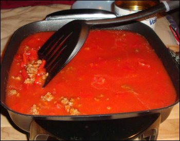 Mixing all of the tomato sauce mixture together for beefaroni.