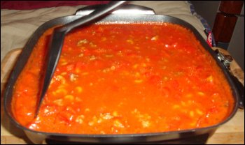 Mixing the pasta into the beefaroni tomato sauce mixture.
