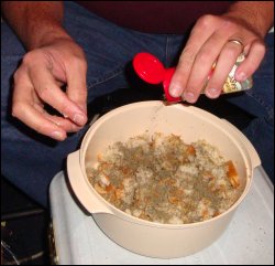 After dampening the bread, adding in two beaten raw eggs, and mixing the ingredients thoroughly, he added the most important spice or seasoning for making bread dressing, rubbed sage. He remixed the ingredients to make sure the sage was evenly distributed.