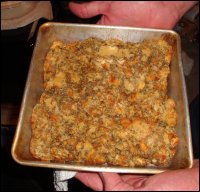 Mike holds the pan of baked bread dressing. He baked it at 350 degrees F for about 20 minutes, long enough to where the eggs were cooked through and the top of the dressing was slightly crisp.